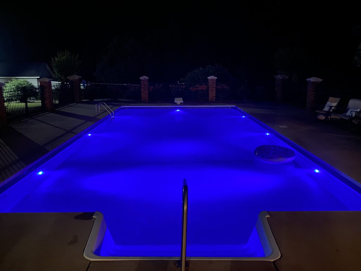 Inground pool with blue LED underwater lighting at night