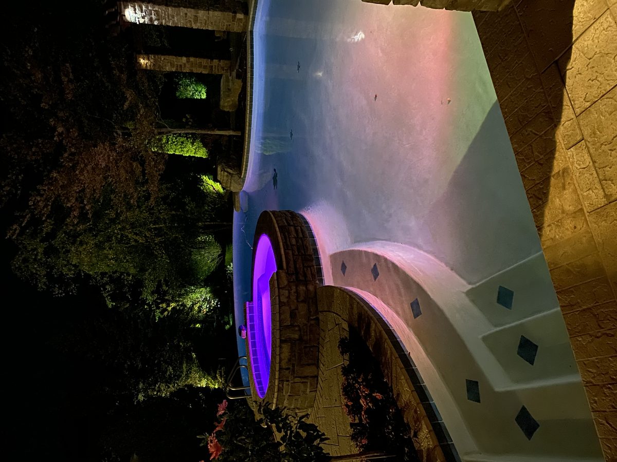 Custom concrete pool with LED lighting at night